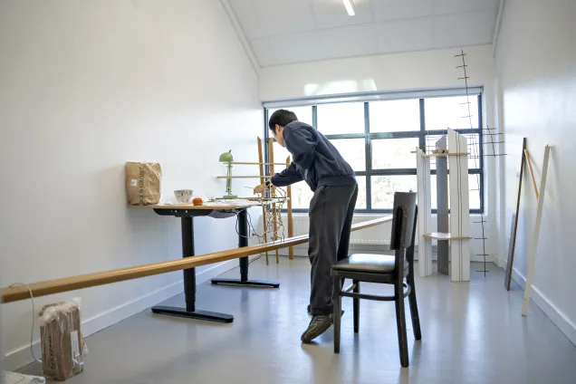 En person som jobbar i sin studio. Foto.