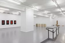 vitt galleri med grått golv och konstverk på väggarna och golvet